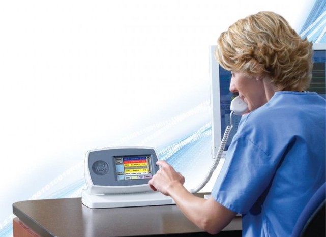 A nurse uses a nurse call system to track and assess a patient's health status in a hospital environment.