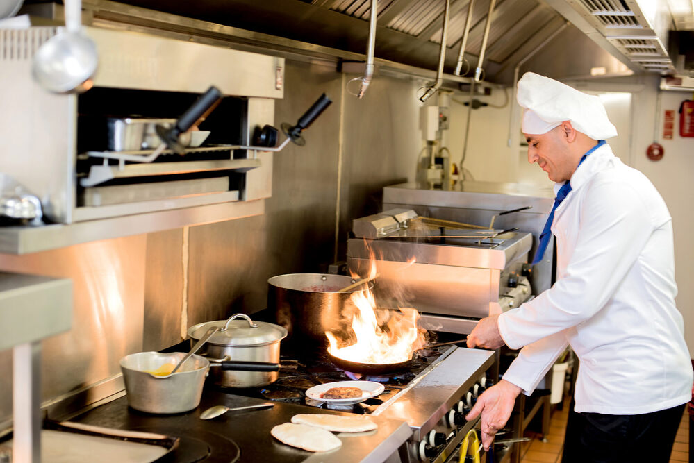 Chef frying a dish in hotel kitchen